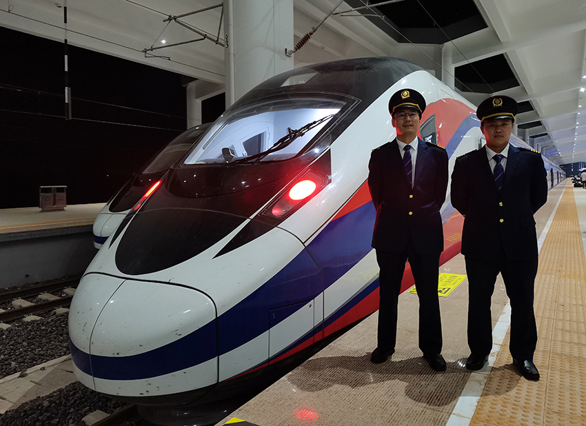 劉銀能（右一）與中國師父鄔俊鴻在動(dòng)車組前合影。受訪者供圖